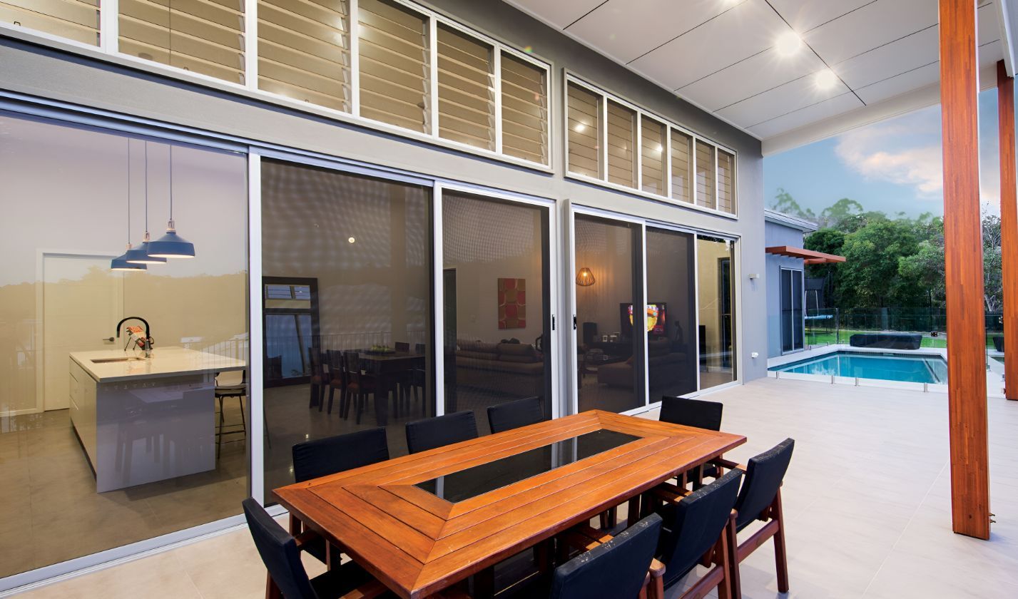 A Patio With a Table and Chairs and a Pool in the Background β South Burnett Garage Doors In Kingaroy, QLD