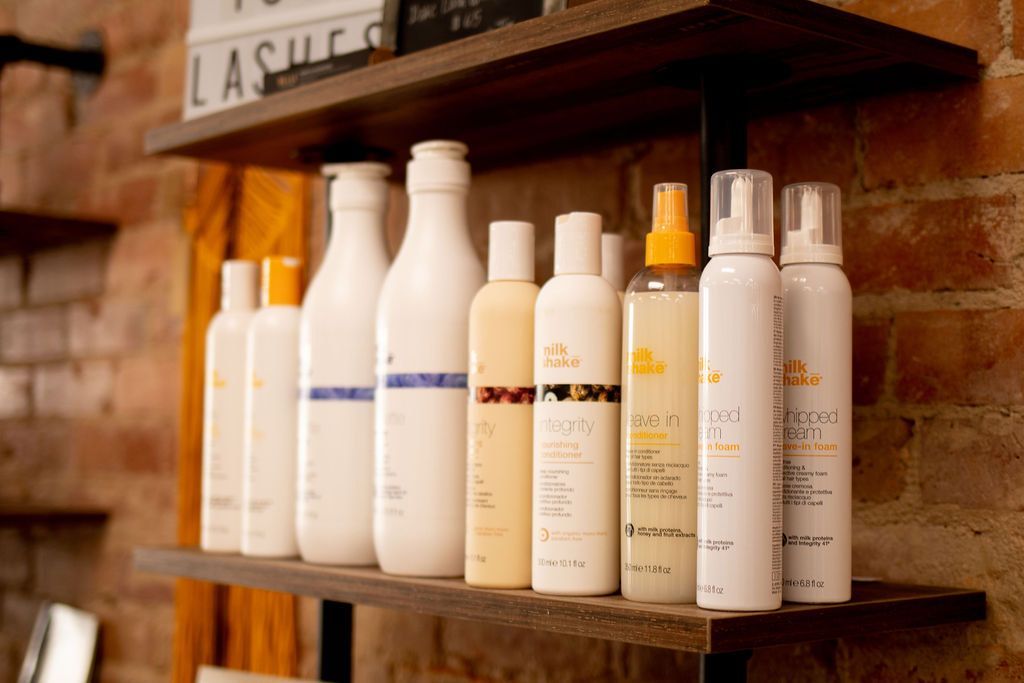 A shelf filled with bottles of hair products in a salon.