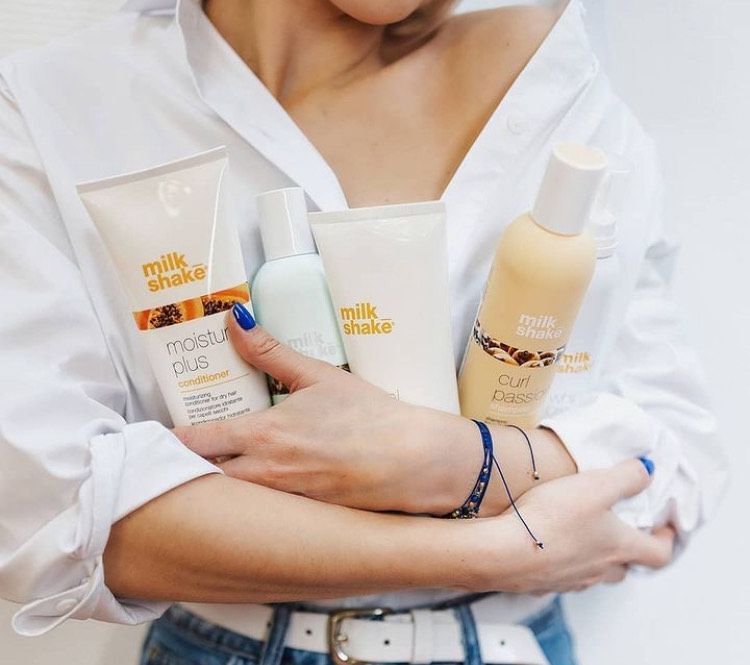 A woman is holding bottles of milk shake products