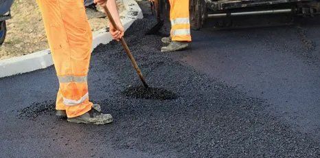 worker filling in asphalt