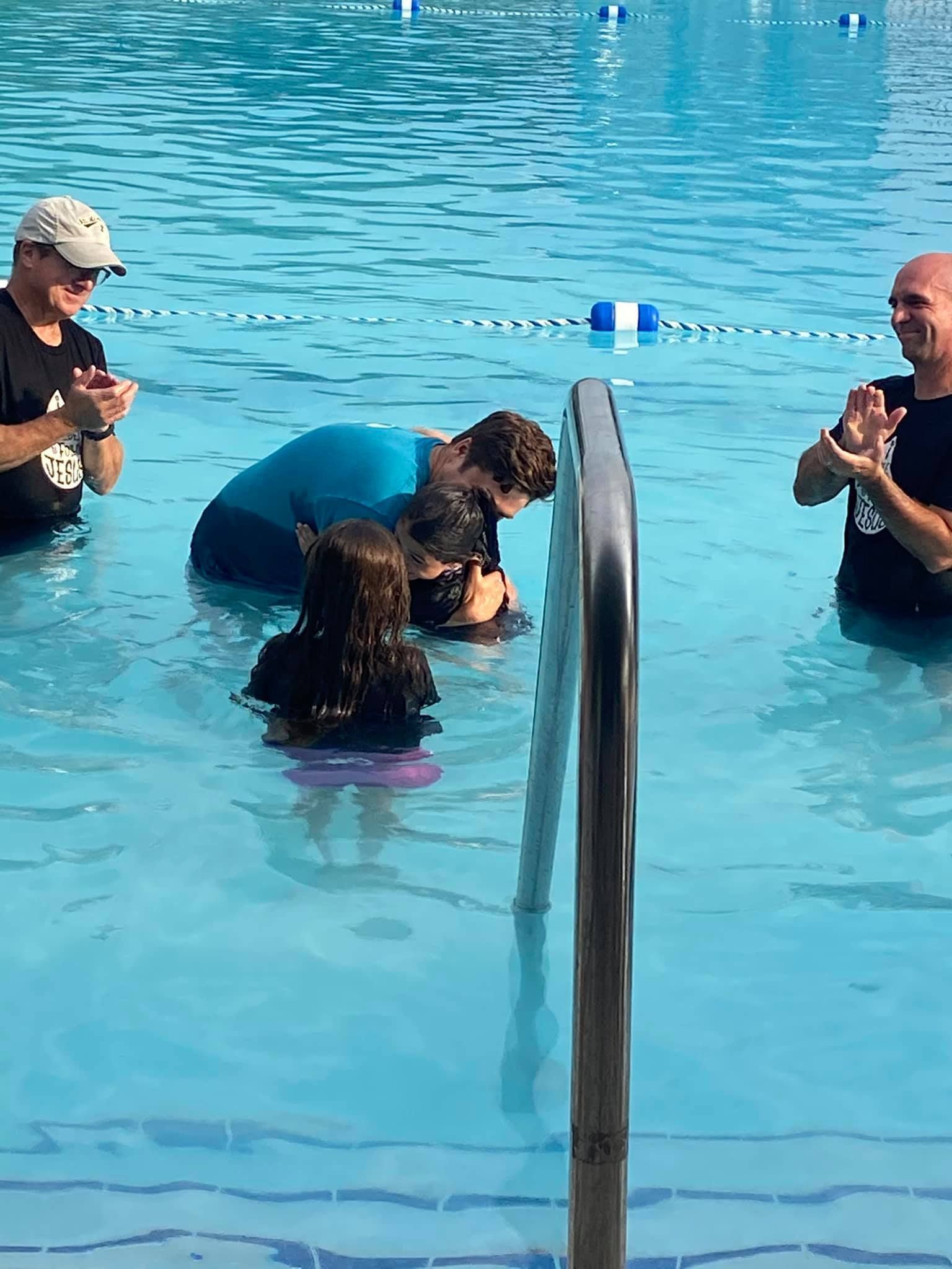 A group of people are standing in a swimming pool.
