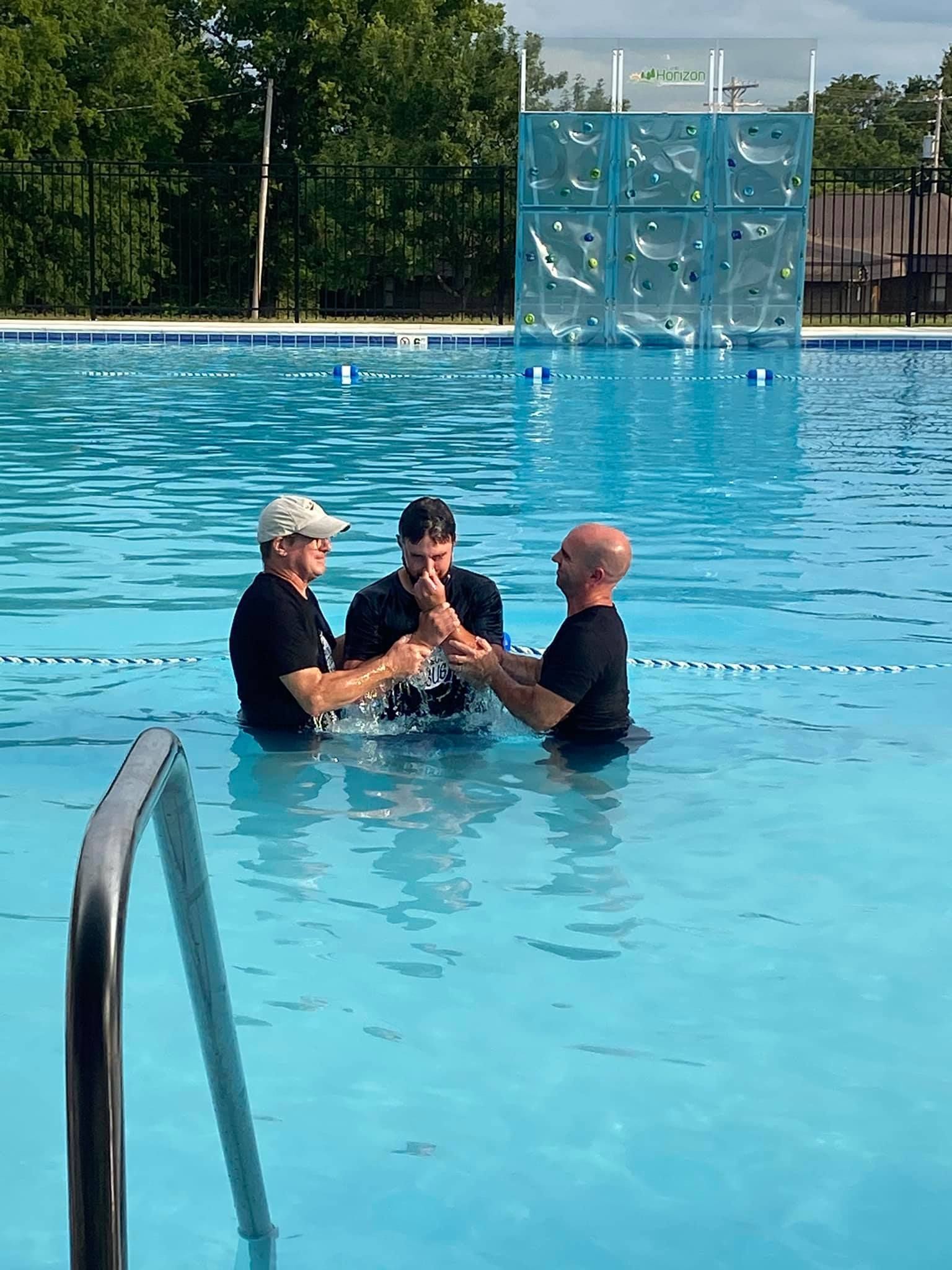 A group of people are standing in a swimming pool.