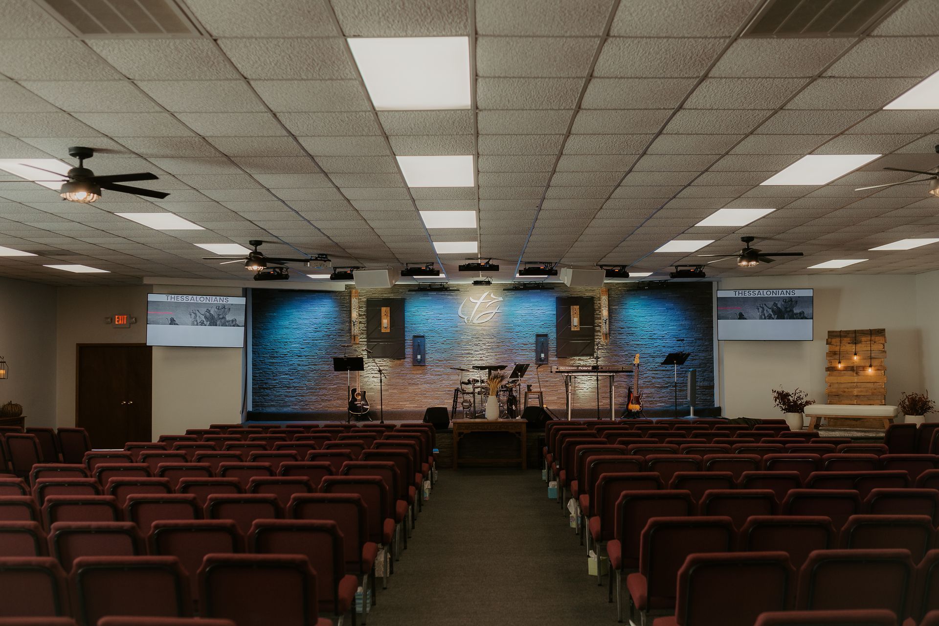 A large church filled with rows of red chairs and a stage.