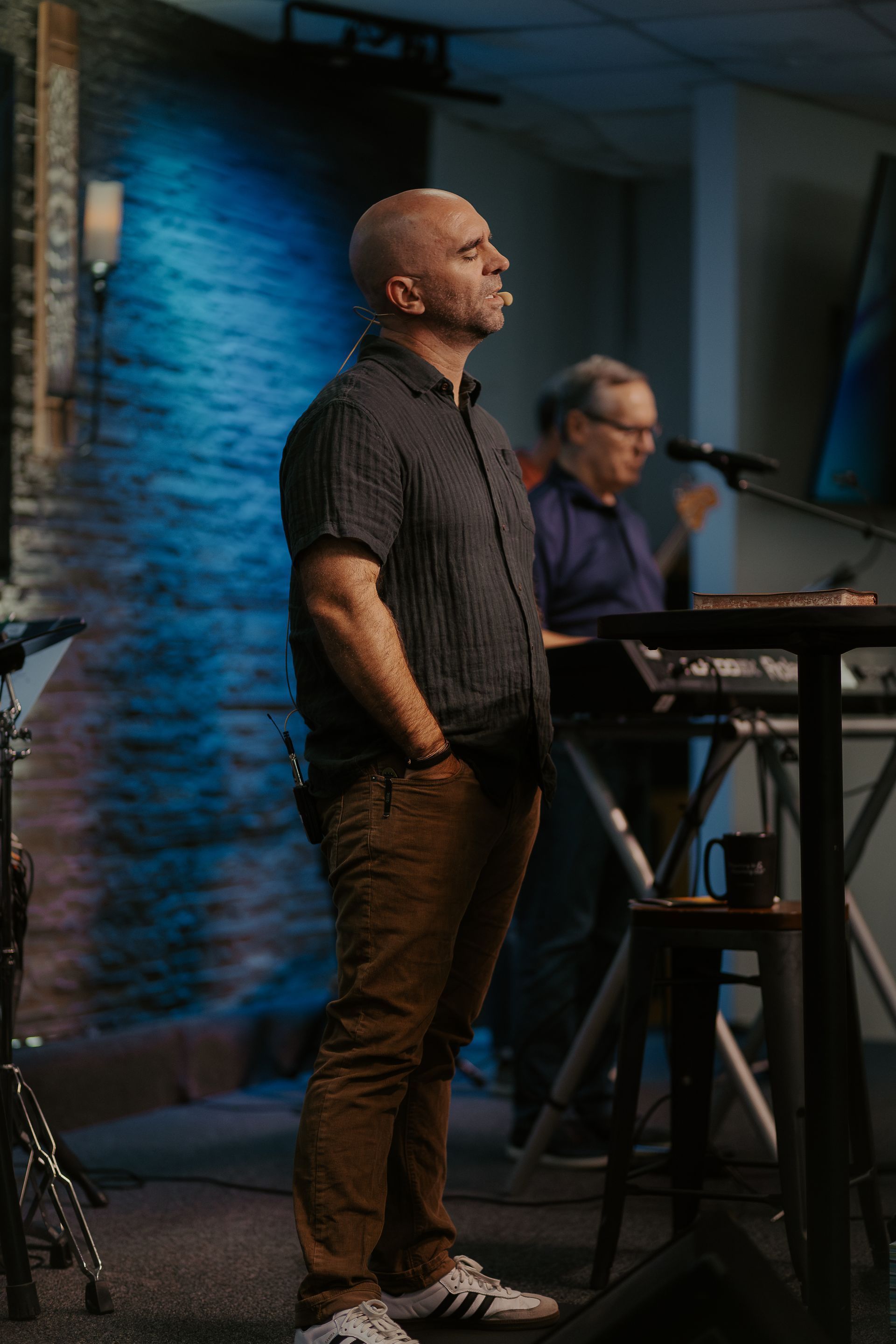 A man is standing in front of a microphone in a room.