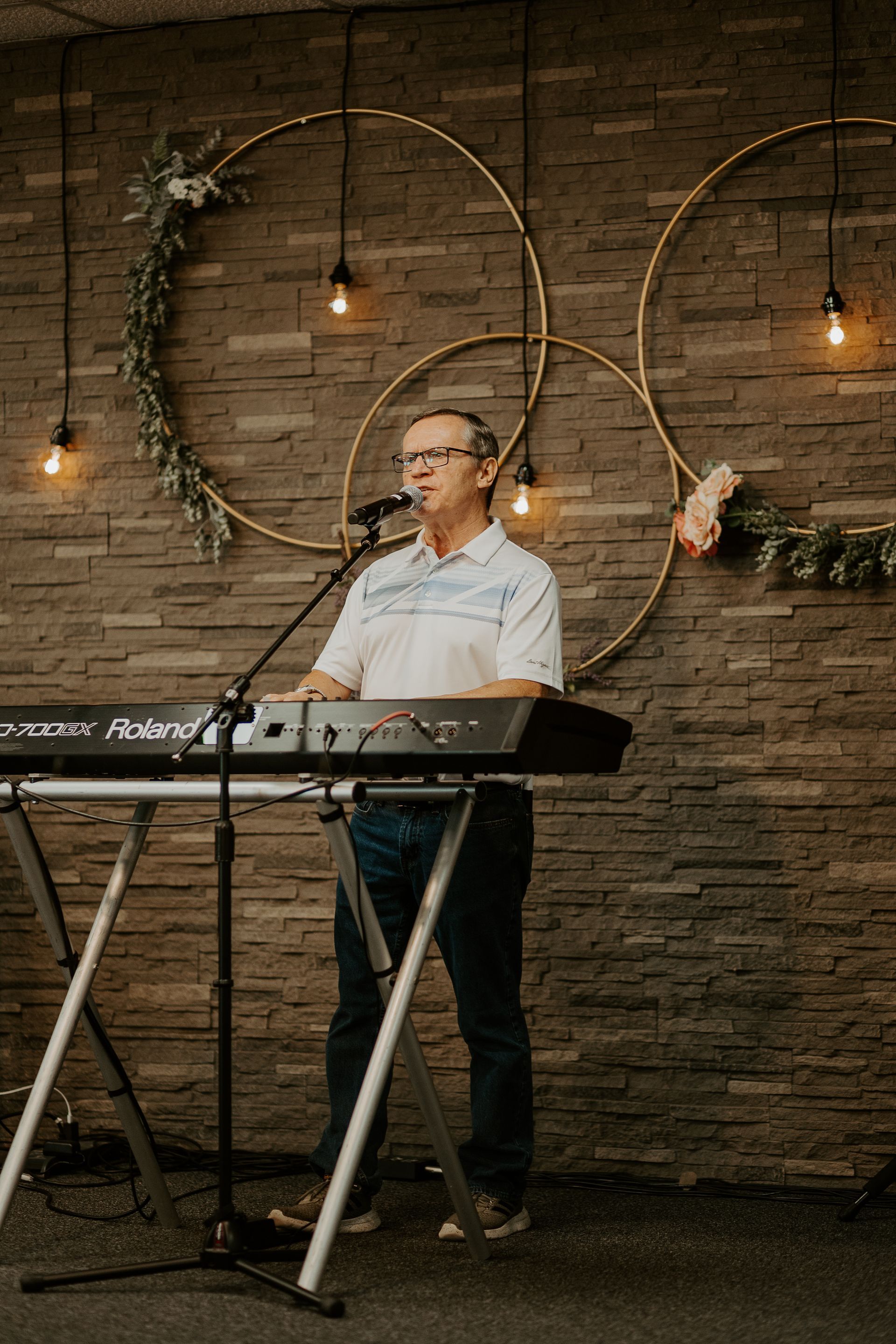 A man is playing a keyboard and singing into a microphone.