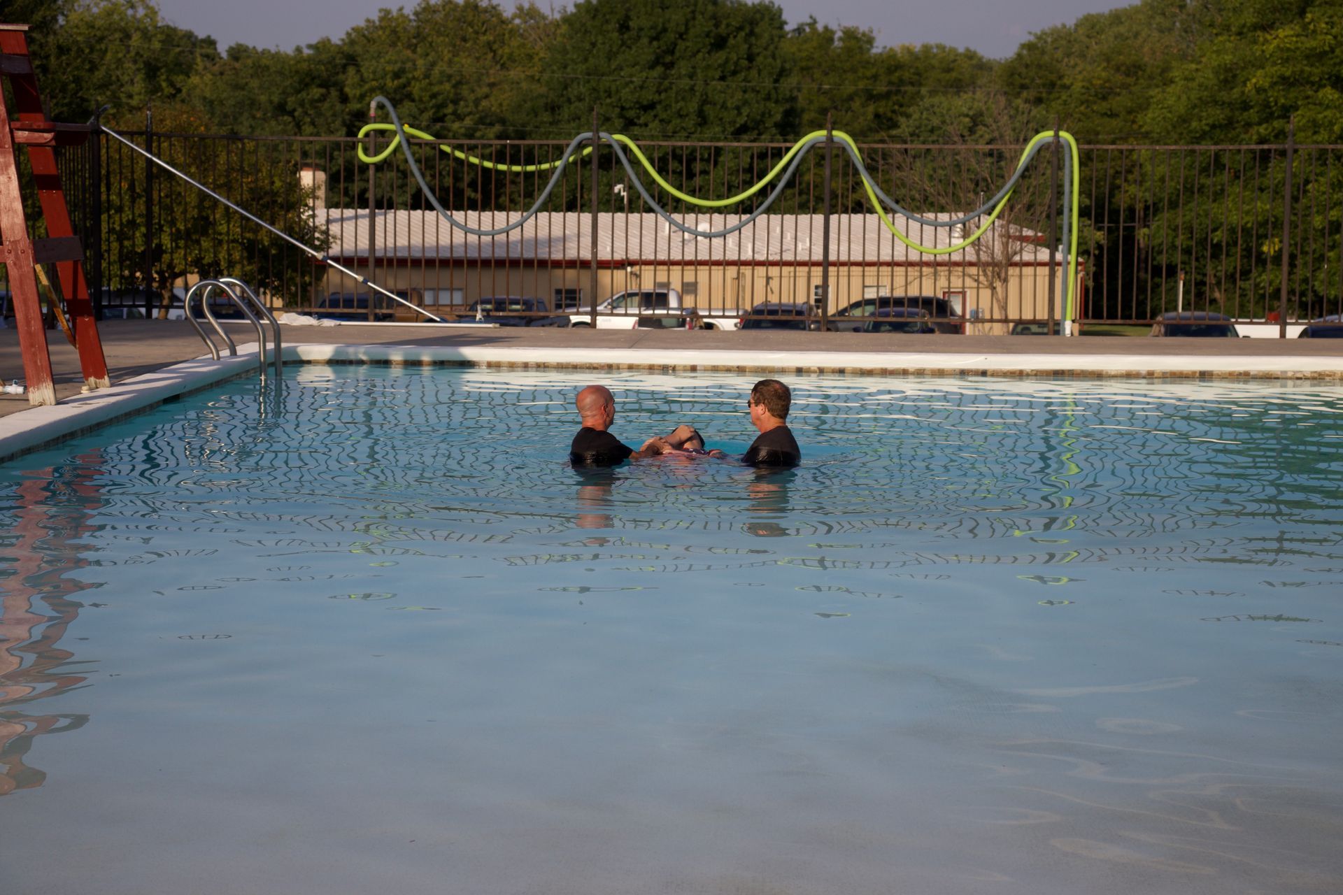 Two people are in a swimming pool.
