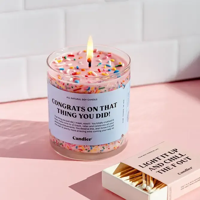 A candle that says congrats on that thing you did