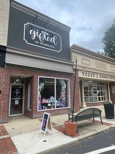 A brick building with a black sign that says gifted on it.