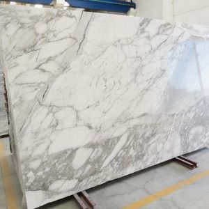 Large slab of white marble with gray veining, likely for construction.