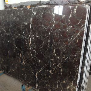 Brown marble slabs with white veining stacked.