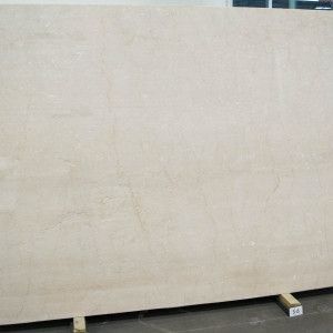 A large, beige marble slab propped up on wooden supports.