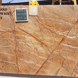 Large slab of golden-brown marble with white and brown veining, with a size tag attached.