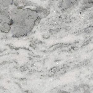 White and gray marble countertop with flowing veins and speckles.