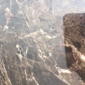 Brown marble tile with white and darker brown veining.