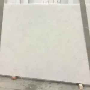 A large, light gray rectangular stone slab laying on wooden blocks.