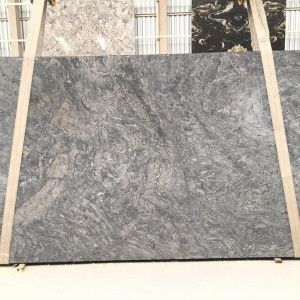 A large, gray and brown stone slab with flowing patterns, standing upright.