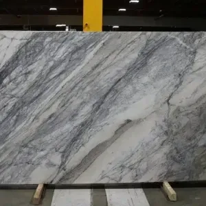 Large slab of white marble with gray veining, displayed on wooden supports.