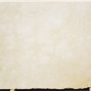 Cream-colored stone slab with subtle veining and a rough bottom edge.