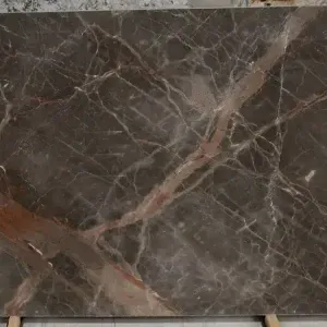 Brown marble slab with reddish and white veining.