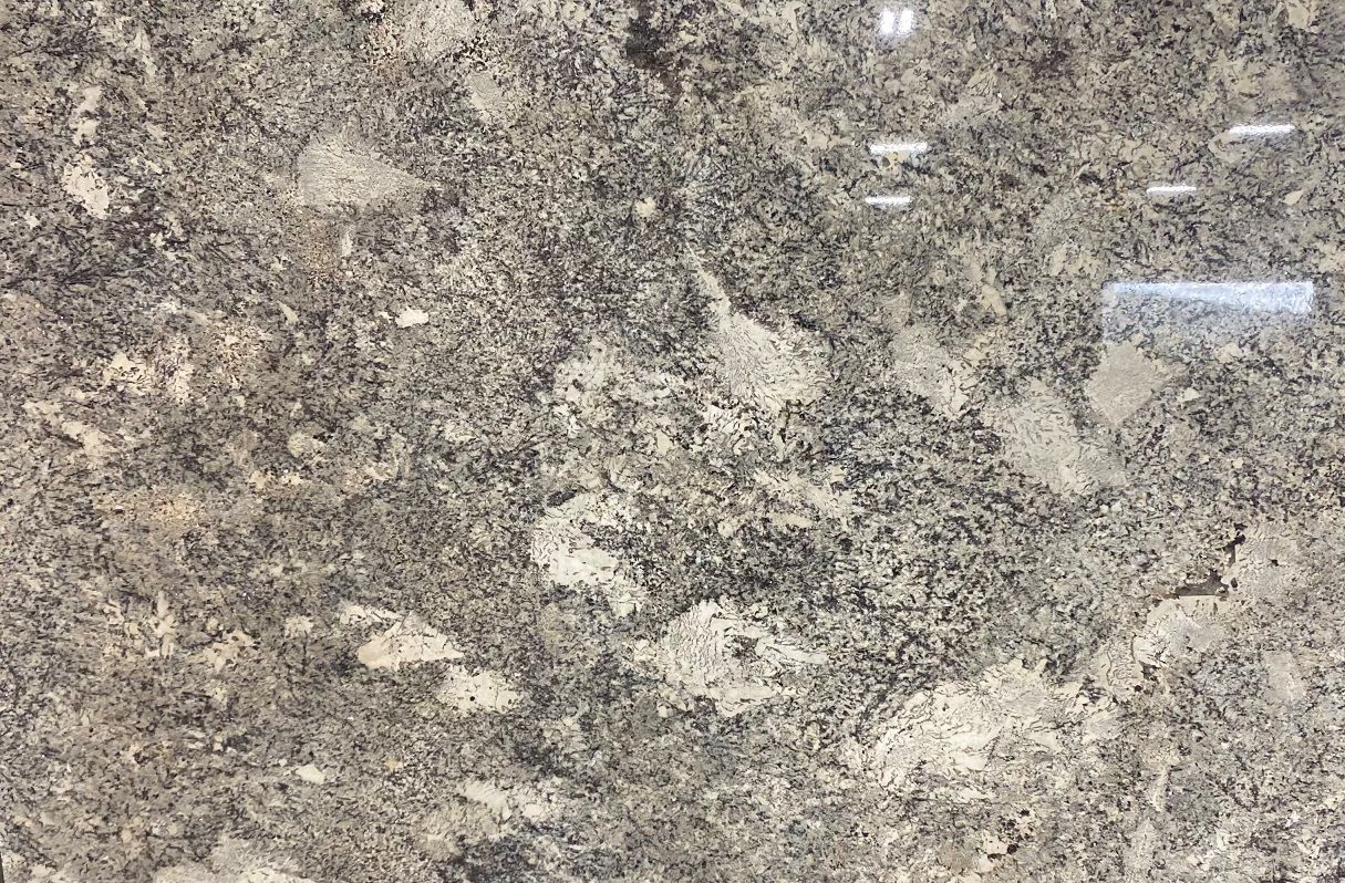 Granite surface, dark gray with light beige and black speckles, natural pattern.