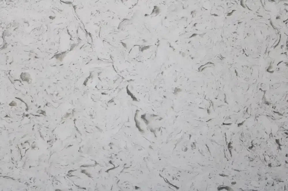 White countertop with swirling gray veining and specks.