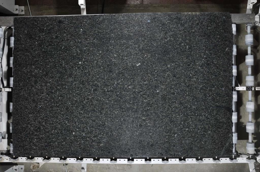 Dark, textured rectangular surface held by a metal frame with rollers, overhead view.