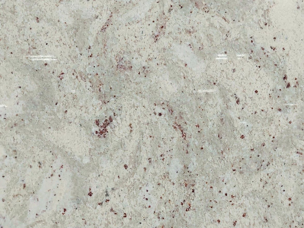 White granite countertop with speckled dark red and gray patterns.