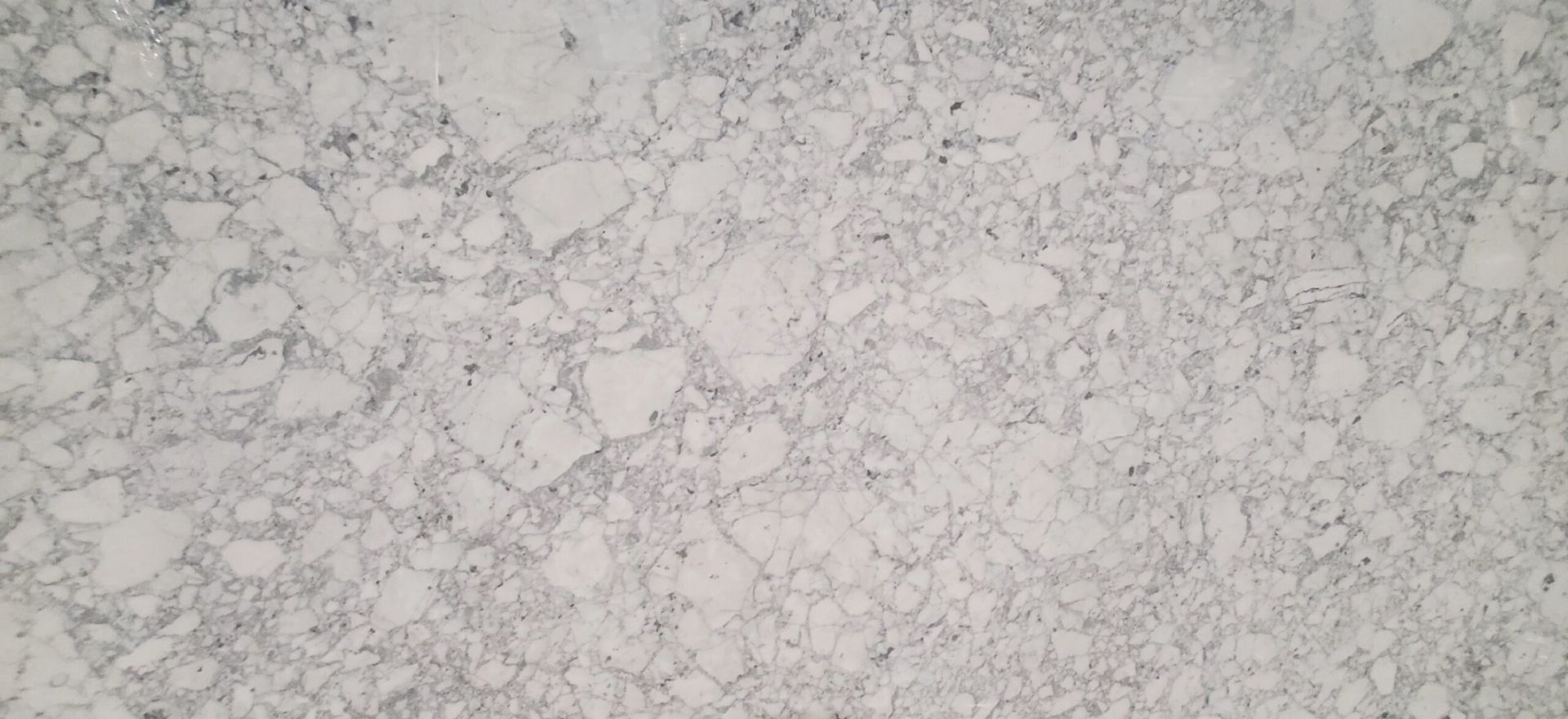 White and gray marbled countertop with irregular patterns and fine black specks.