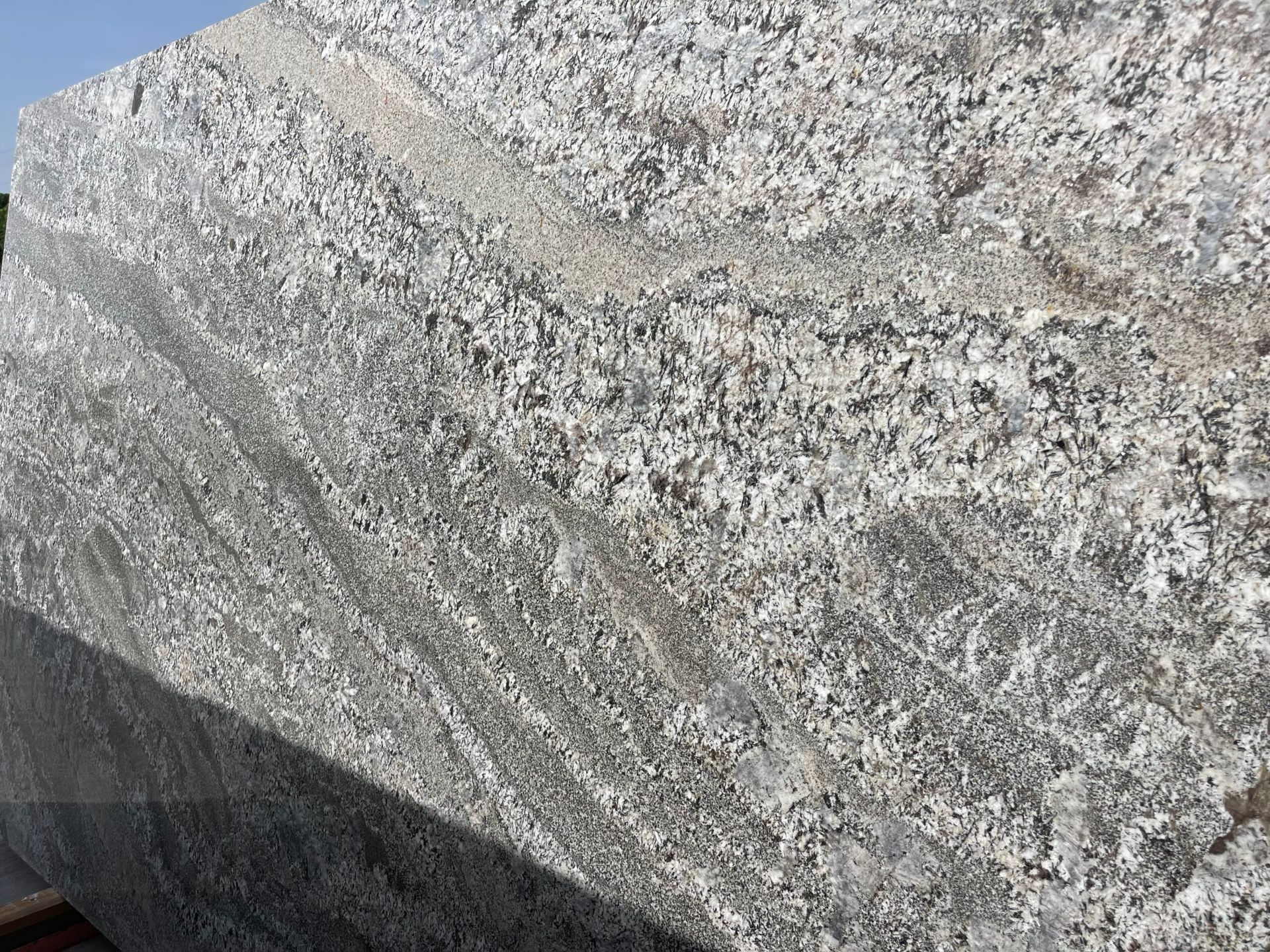 Large slab of gray granite with white and black flecks and linear patterns.