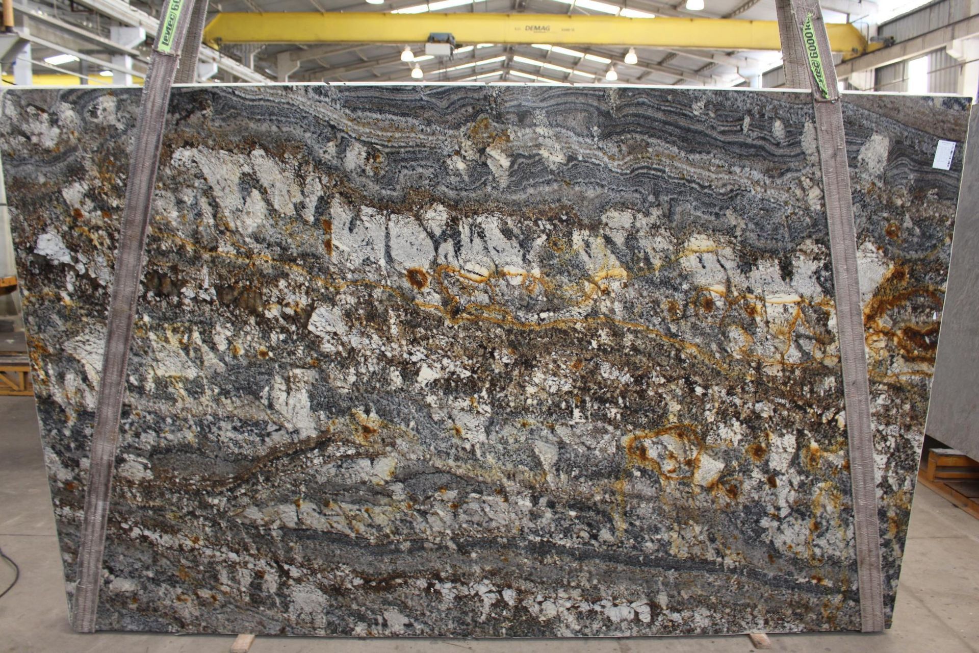 Large slab of granite with swirling gray, gold, and white patterns.
