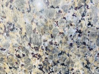 Granite countertop with beige, gray, and dark brown speckled pattern.