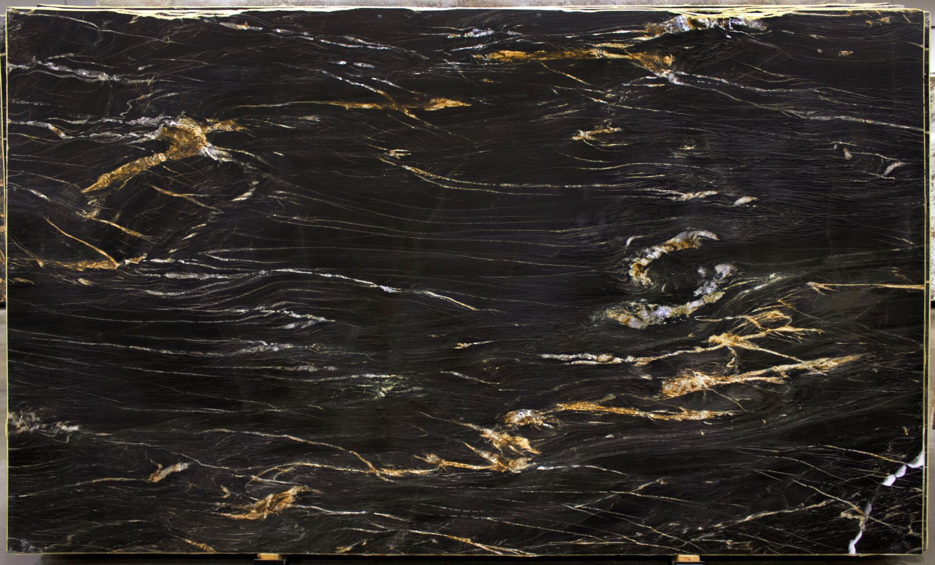 Black granite slab with gold and white veining.