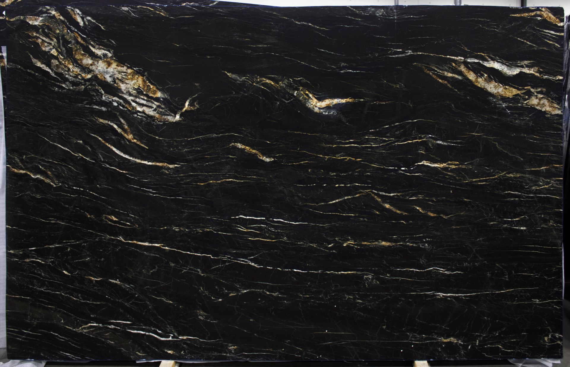 Black granite slab with gold and white veining.