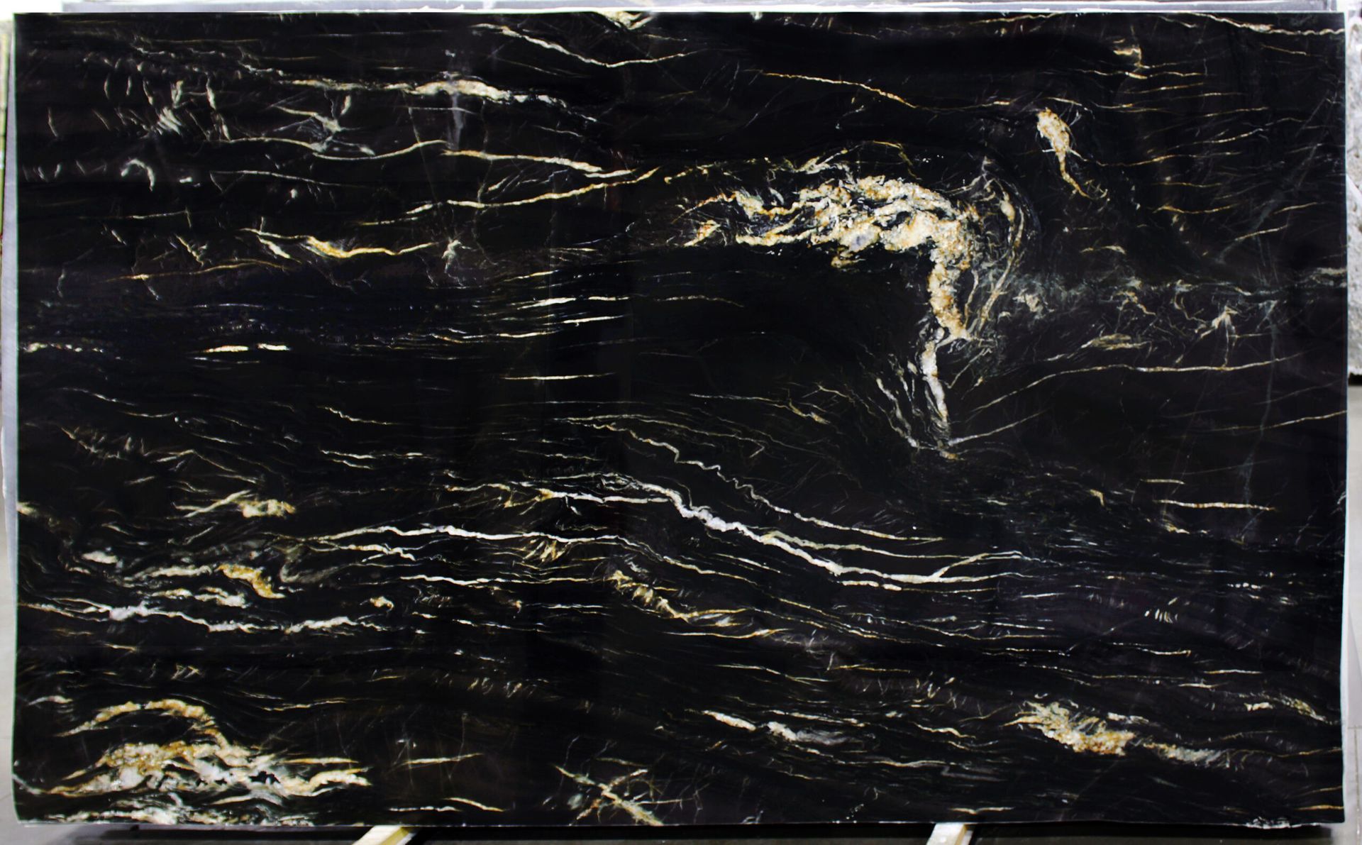 Black granite slab with gold and white veining.