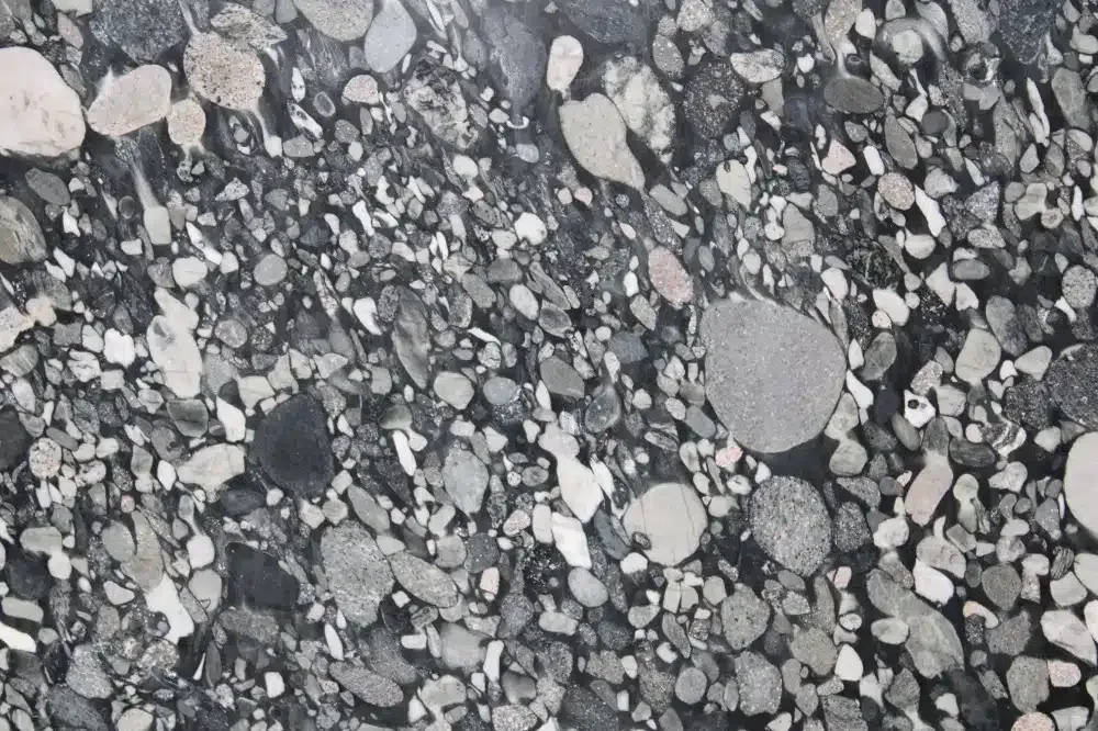 Close-up of a dark gray granite surface with various sized, rounded gray and white flecks.