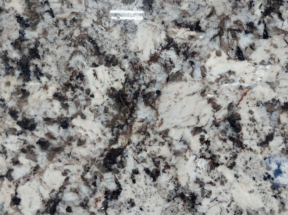 White and grey granite countertop with black and brown flecks.