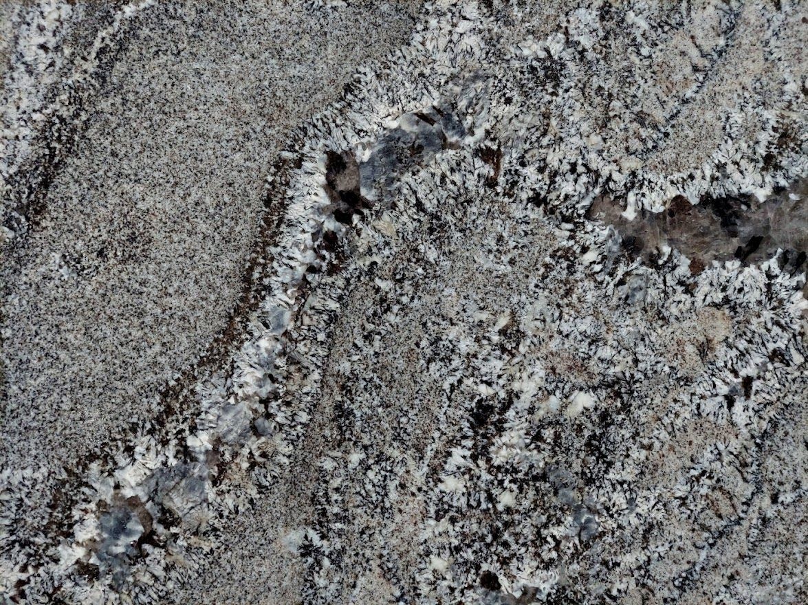 Textured gray stone with light and dark speckled areas, a vein of white crystals.