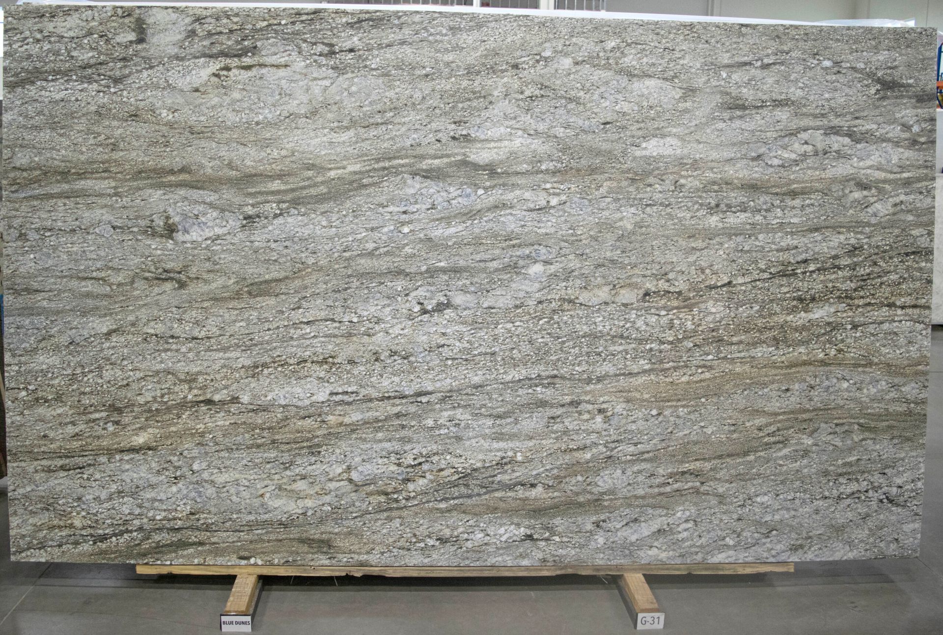 Large slab of granite with flowing beige and gray patterns.