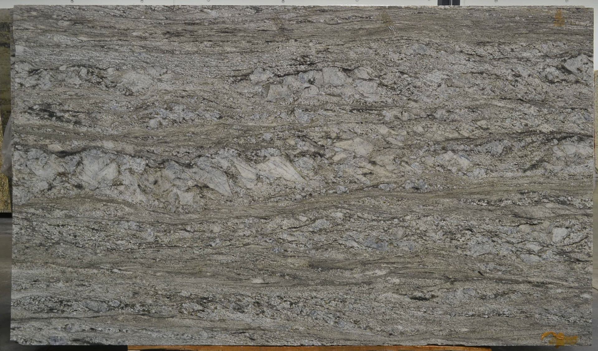 Gray and tan granite slab with flowing, linear patterns.