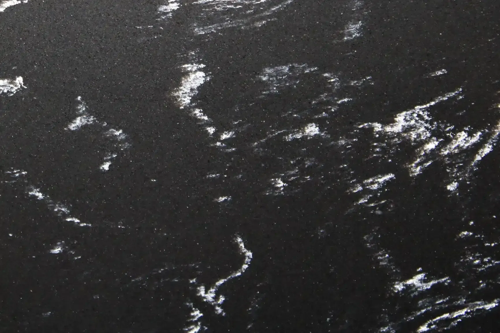 Black surface with white swirling patterns.