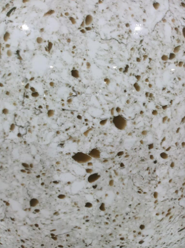 White countertop with brown speckles and veining.