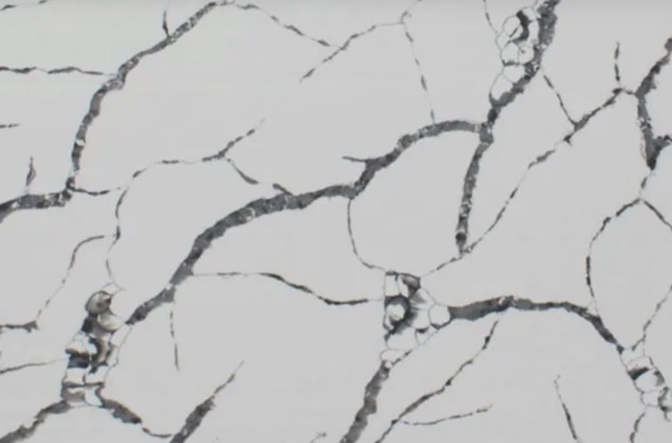White surface with dark gray veining resembling cracked marble.