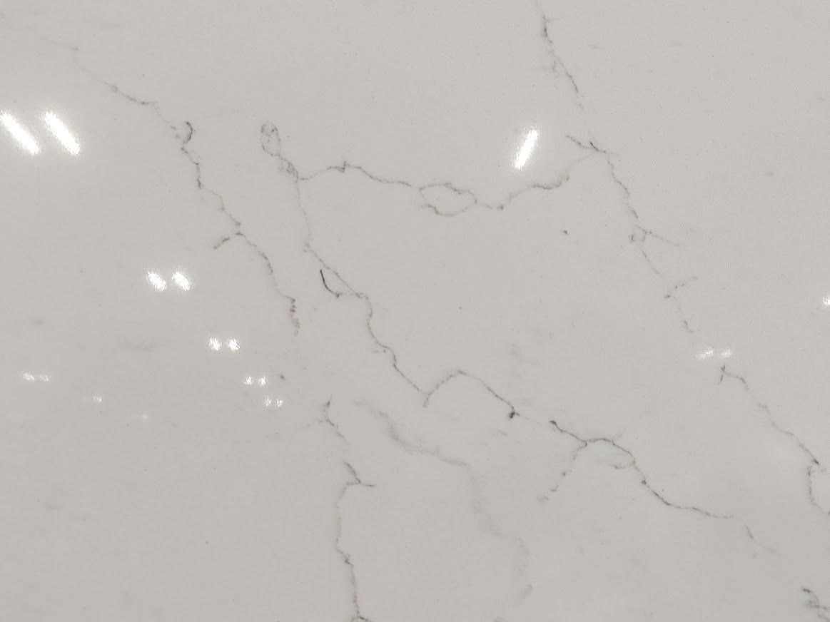White countertop with grey veining, reflecting overhead lights.
