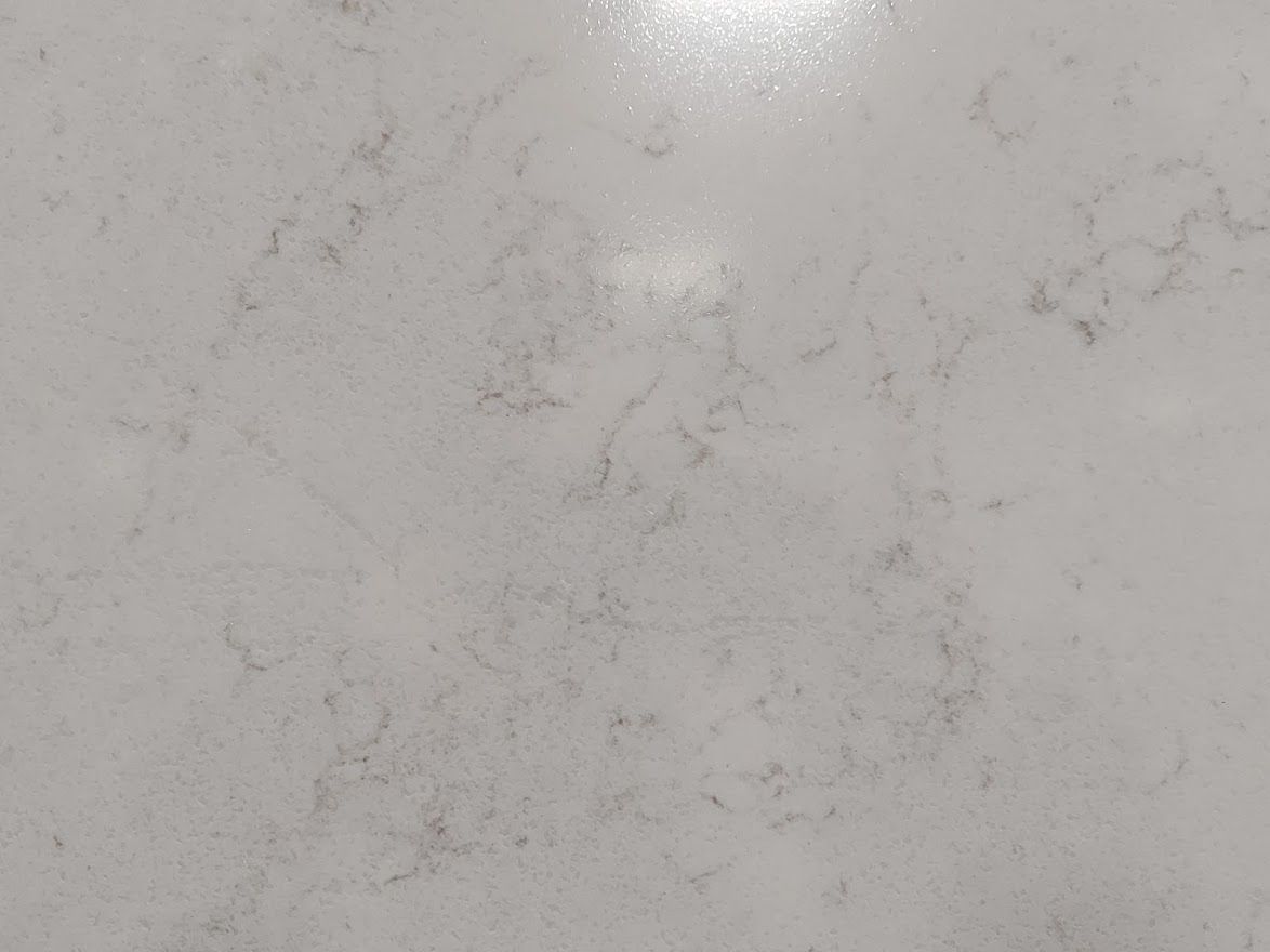 White countertop with subtle gray and purple veining, reflecting light.