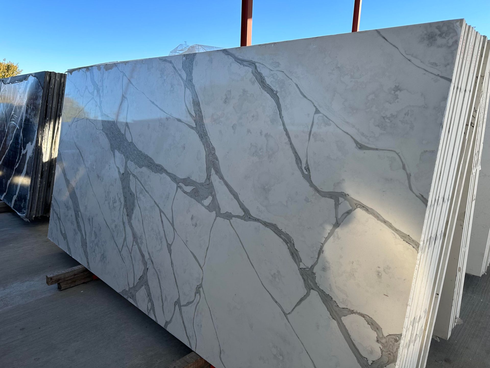 White marble slabs with gray veining stacked outside.