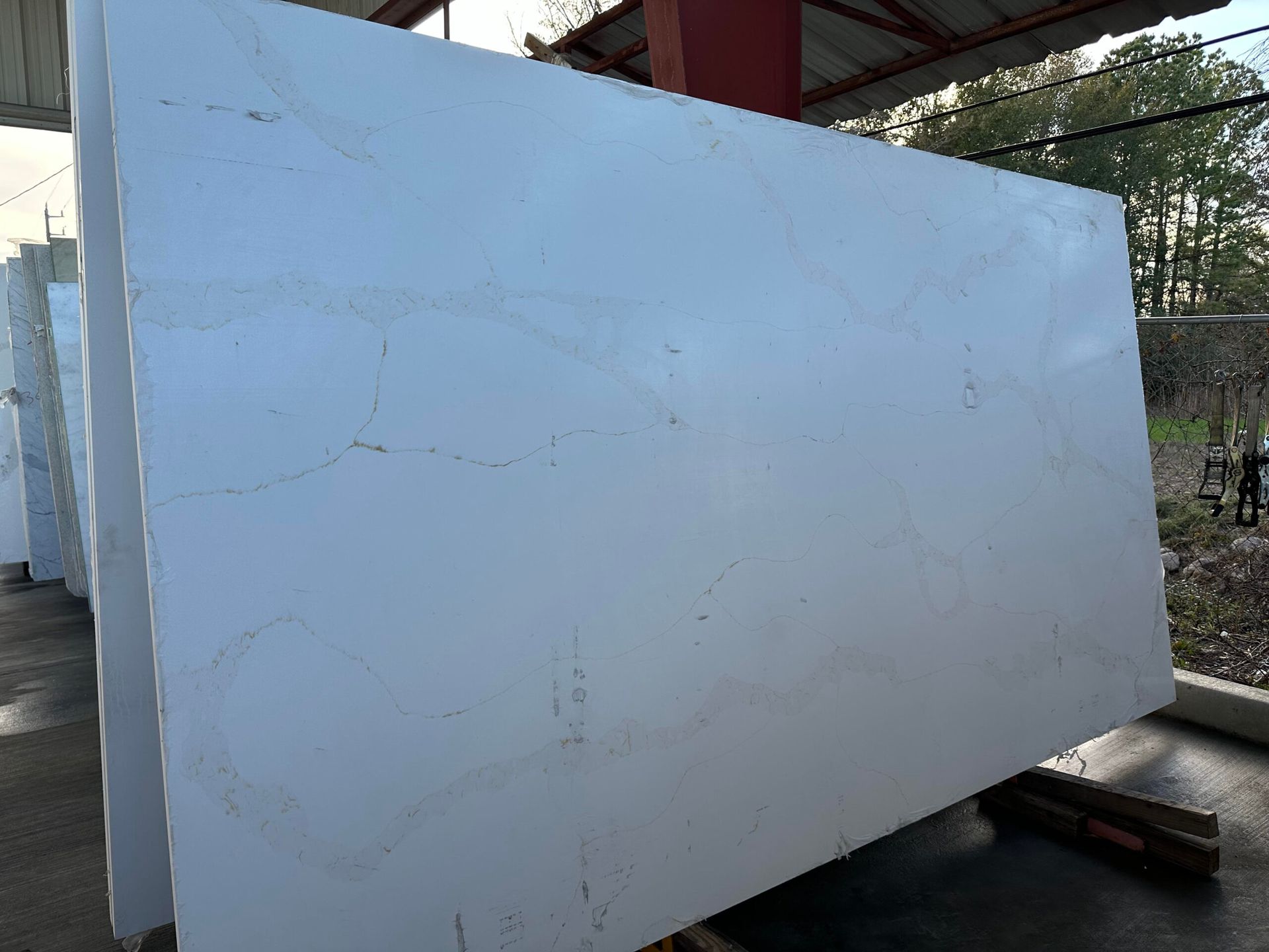 Large white stone slabs with subtle veining, stacked outdoors.
