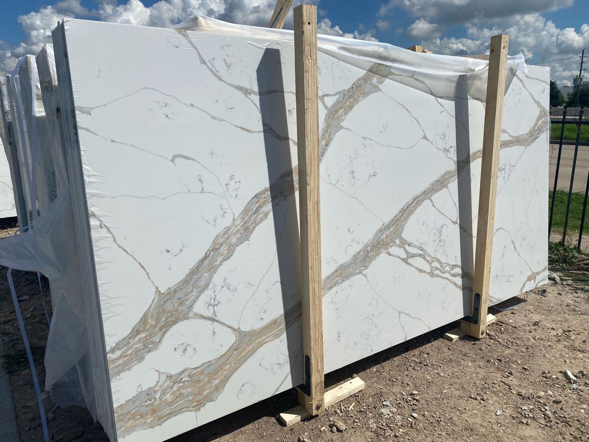 Quartz countertops with gold veining, stacked outside on a sunny day.