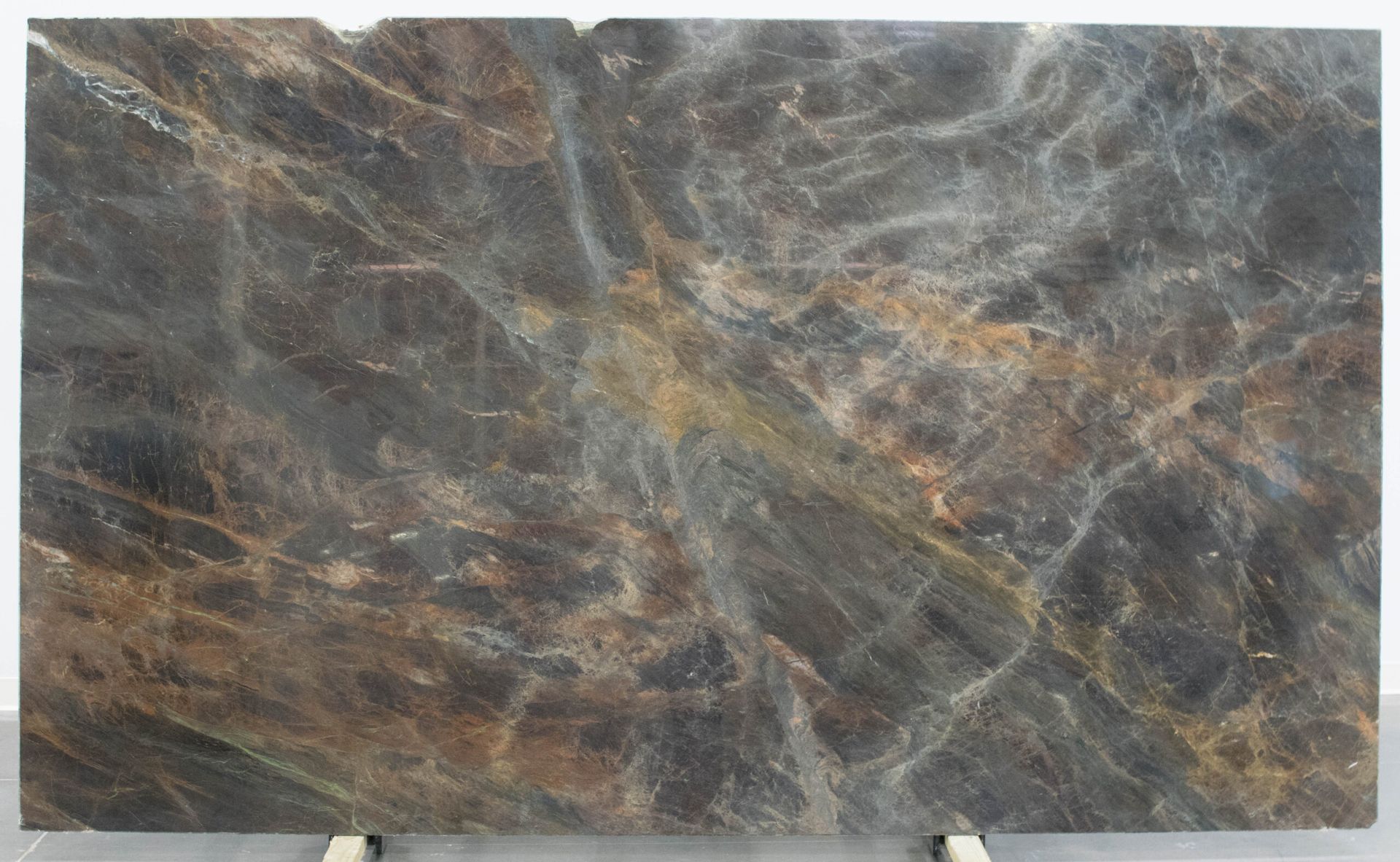 Large, dark brown marble slab with swirling patterns in shades of grey and gold.