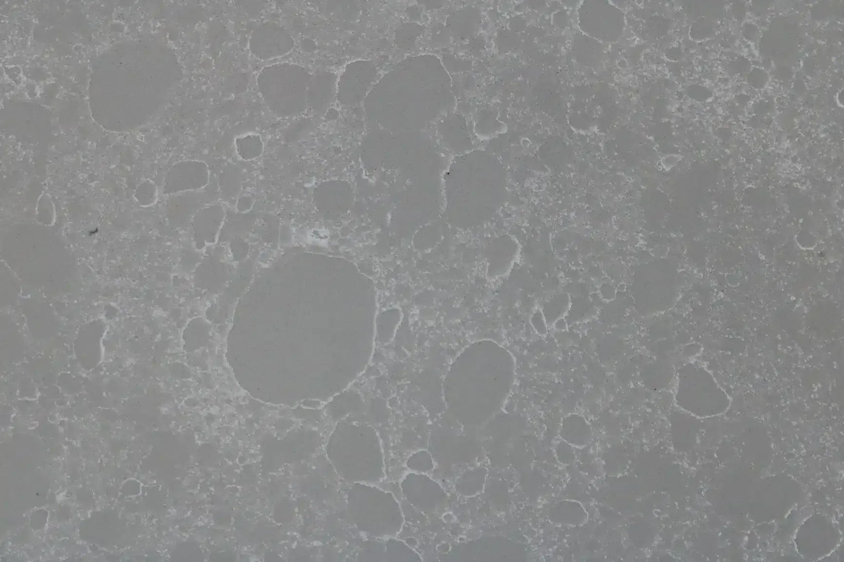 Gray quartz countertop with a speckled pattern and rounded white veining.