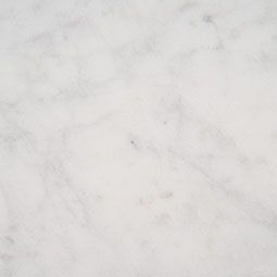 White marble surface with gray veining and small dark spots.